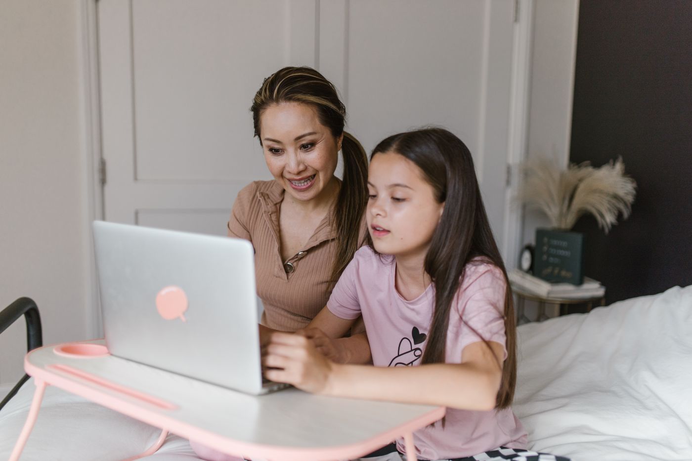 A parent and child using a laptop at home