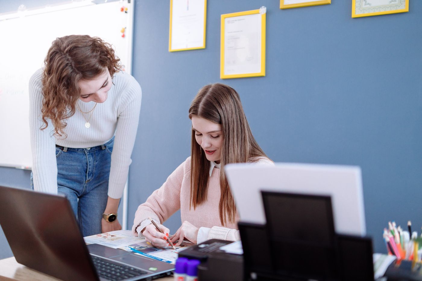 A staff member helping a student at a desk